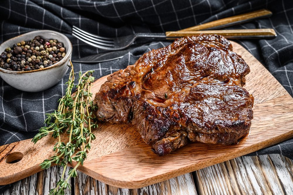 Cooked grilled Chuck eye roll steak on a chopping Board.