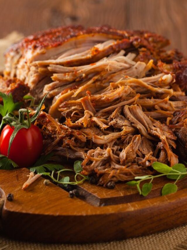 Pulled pork on a wooden board.