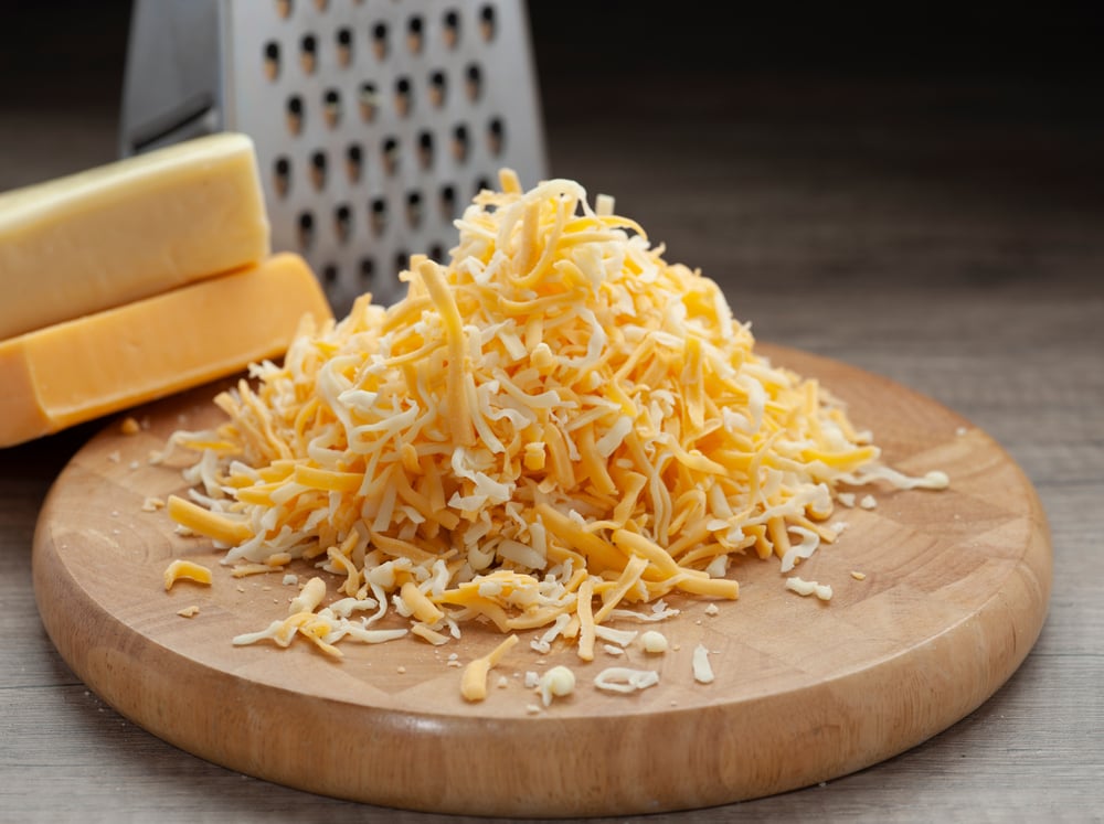 Shredded cheese on a cutting board